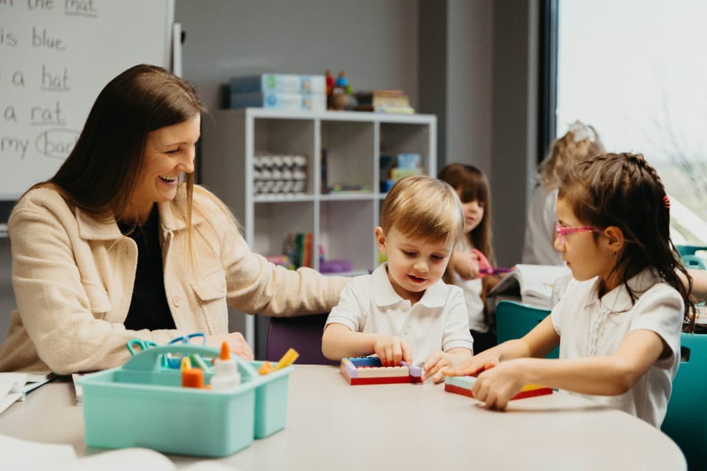 Teacher and students building with blocks in the classroom